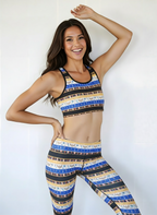 Woman wearing a colorful sports bra and leggings set against a white background