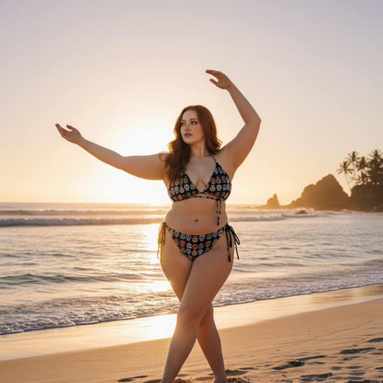 Woman in a bikini standing on a beach with sunset in the background