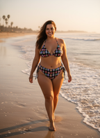 Woman in a floral bikini walking on a beach at sunset