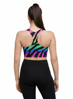 Woman wearing a colorful zebra print sports bra and black leggings on a white background
