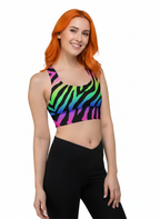 Woman wearing a colorful zebra print sports bra and black leggings on a white background