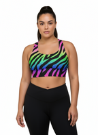 Woman wearing a colorful zebra print sports bra and black leggings on a white background