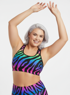 Woman wearing a colorful zebra print sports bra against a white background
