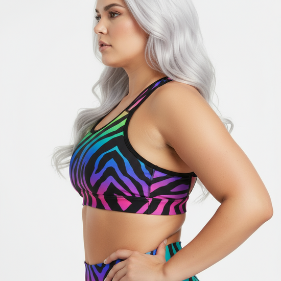 Woman wearing a colorful zebra print sports bra against a white background