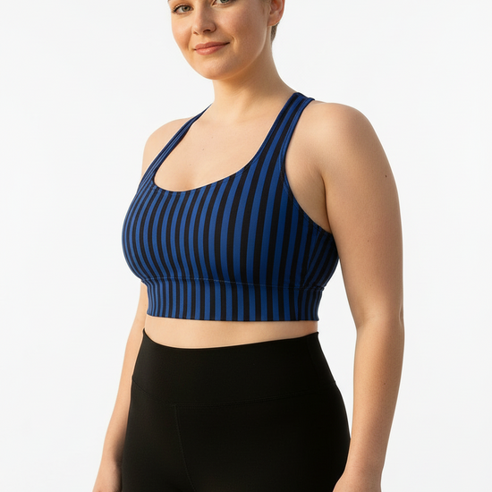 Woman wearing a blue striped sports bra and black leggings on a white background
