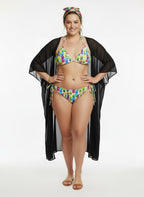 Woman wearing a colorful bikini with a black cover-up on a white background