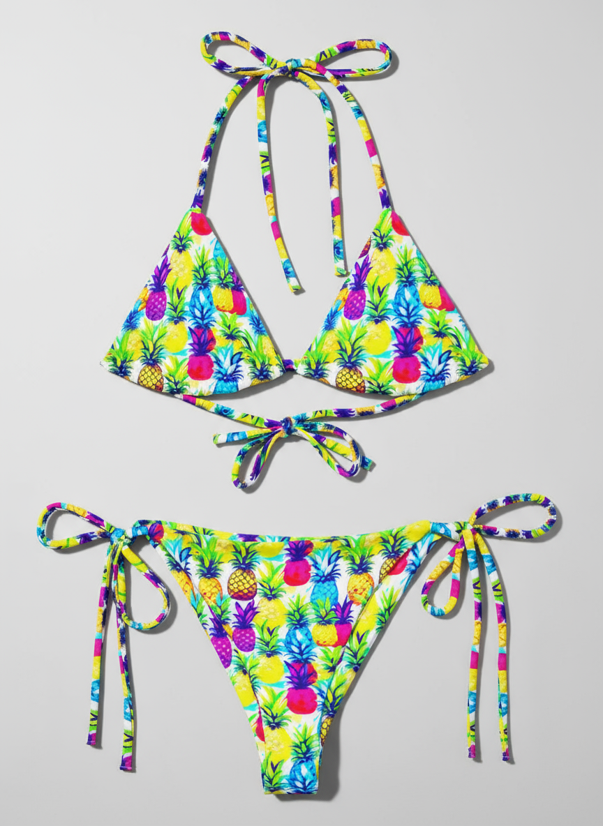 Flat lay of recycled string bikini in colourful yellow, pink, purple and blue pineapple print.