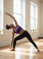 Woman in a yoga pose in a bright room with large windows