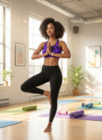 Woman practicing yoga in a studio with colorful mats on the floor.