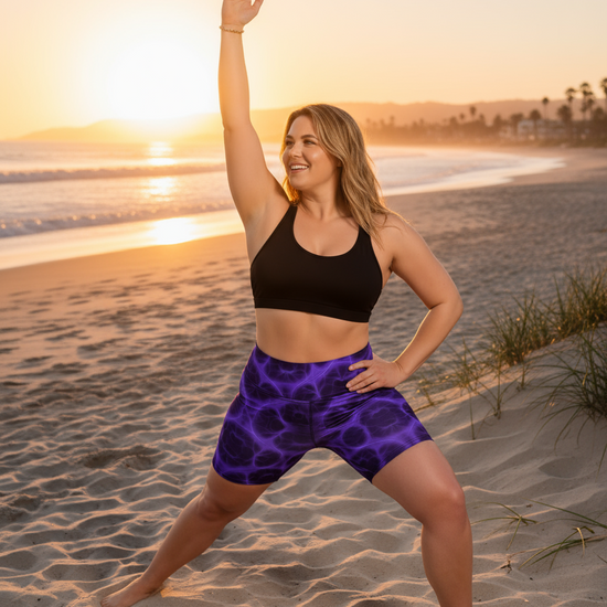 Woman in athletic wear standing on a beach at sunset