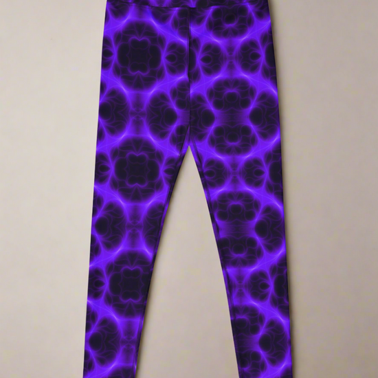 Front flat‑lay view of Violet Voltage Yoga Leggings, featuring a bold symmetrical pattern in shades of purple and black. Kaleidoscopic, floral‑inspired design with repeating circular motifs, displayed against a neutral background.