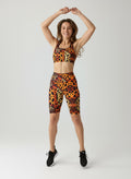 Woman wearing a leopard print sports bra and shorts on a white background