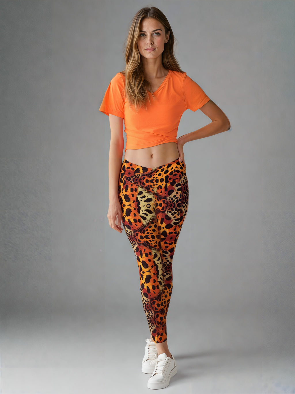 A woman is wearing Wildfire Crossover Leggings featuring a bold animal print pattern in vibrant orange, yellow, and black tones. The leggings have a flattering crossover waistband and a sleek, fitted silhouette. The design is eye-catching and inspired by wild cat prints, with the background kept simple to highlight the leggings' dynamic style.