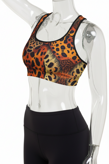 A mannequin wearing a sports bra with an orange, black, and brown leopard print pattern, paired with black leggings, shown against a plain white background.