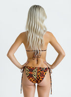 Person wearing a leopard print bikini on a plain background