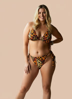 Woman wearing a leopard print bikini against a beige background