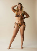 Woman wearing a leopard print bikini against a beige background