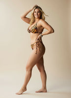 Woman wearing a leopard print bikini against a beige background