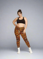 Woman wearing leopard print leggings and black sports bra on a gray background